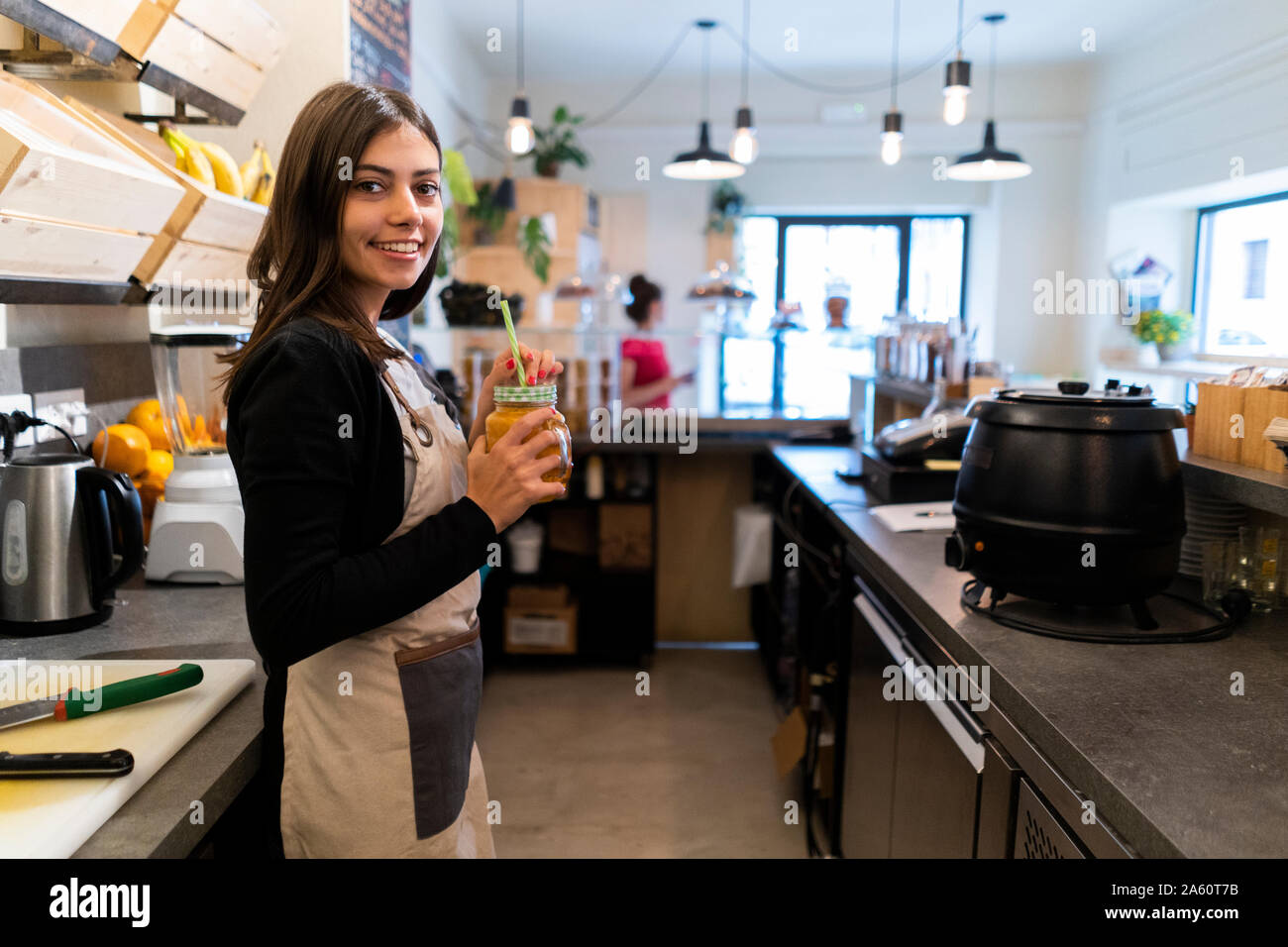 Portrait of smiling young woman behind the counter in a cafe Stock