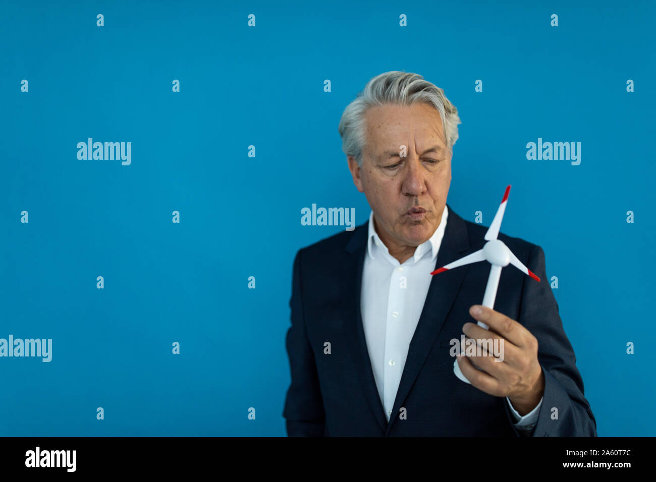 Senior businessman holding wind turbine model Stock Photo