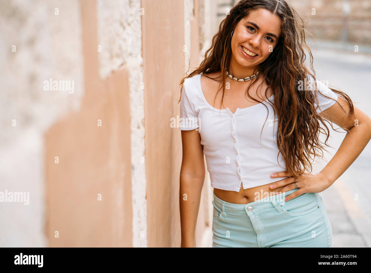 Portrait of beautiful young woman at a wall Stock Photo