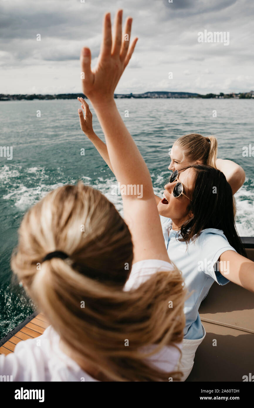 Cheerful female friends on a boat trip on a lake Stock Photo