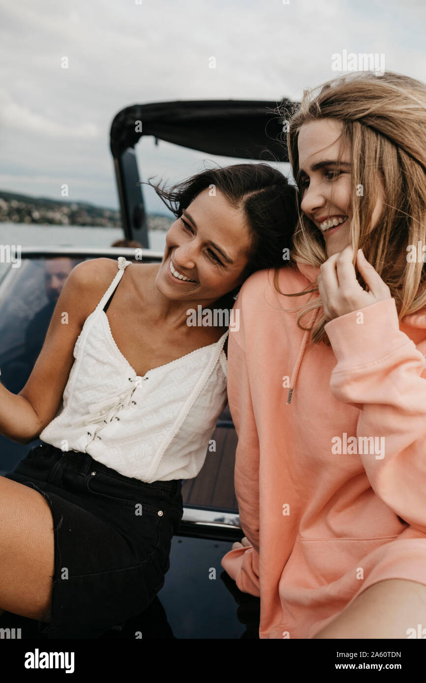 Happy female friends on a boat trip on a lake Stock Photo