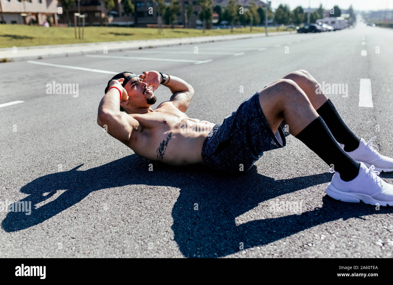 Young man doing sit-ups on a road Stock Photo