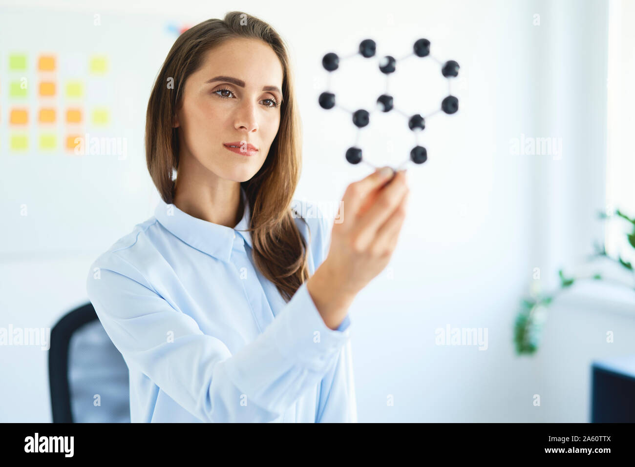 Young female scientist looking at graphene model Stock Photo