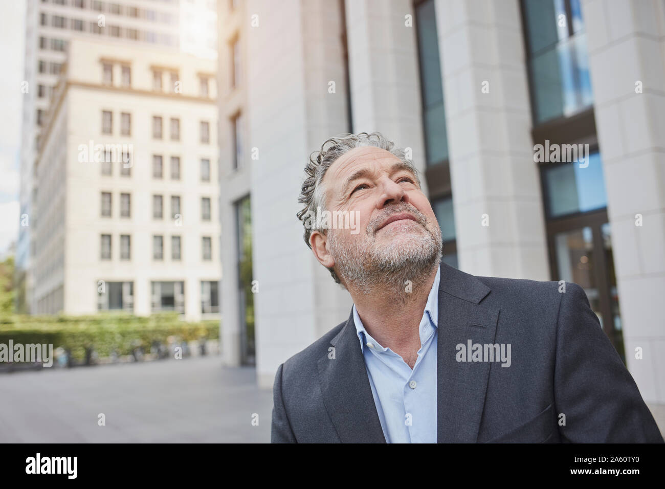 Portrait of confident businessman in the city looking up Stock Photo