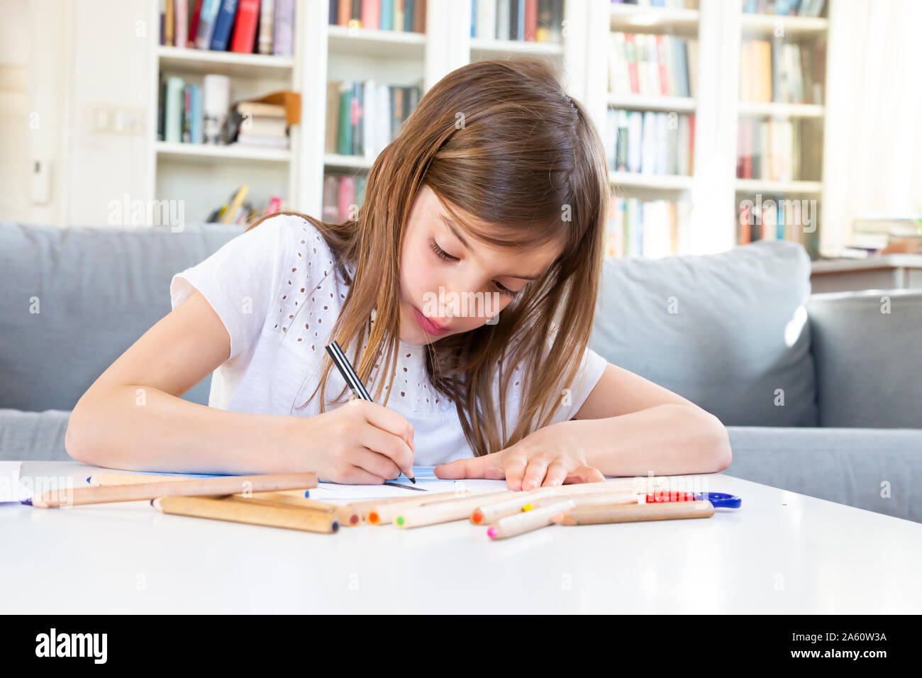 Portrait of girl drawing with coloured pencil at home Stock Photo
