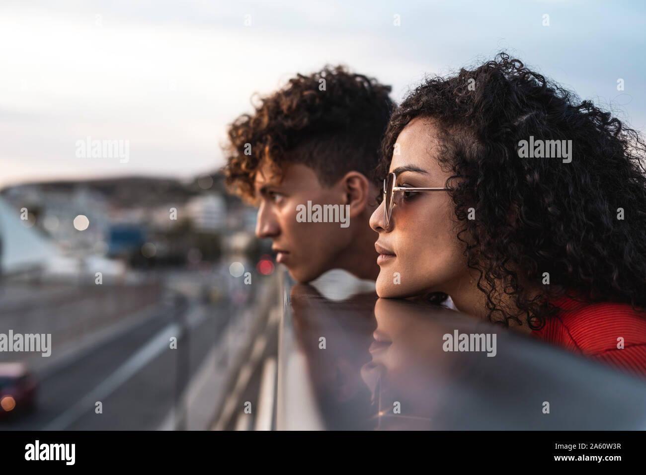 Resting On Railing Young couple on bridge, resting chins on railing Stock Photo - Alamy