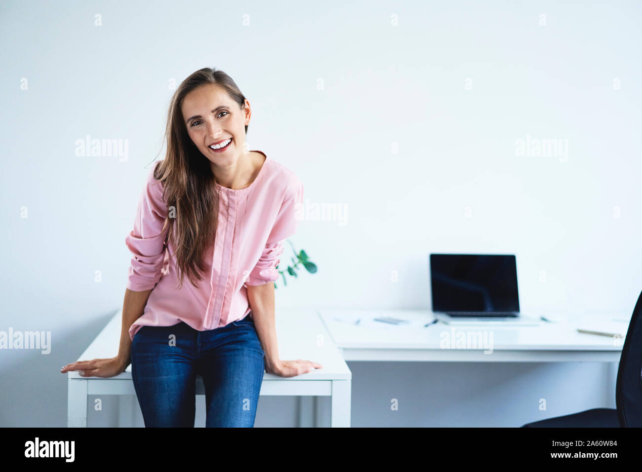 Young woman smiling at camera in office Stock Photo