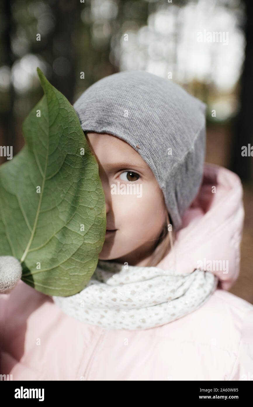 Portrait of a little girl with big green leaf Stock Photo