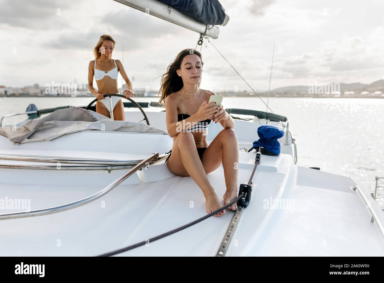Two beautiful women enjoying a summer day on a sailboat Stock Photo