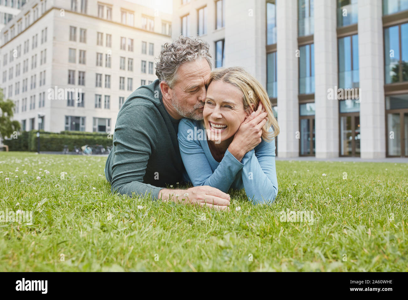 Happy mature couple lying on lawn in the city Stock Photo