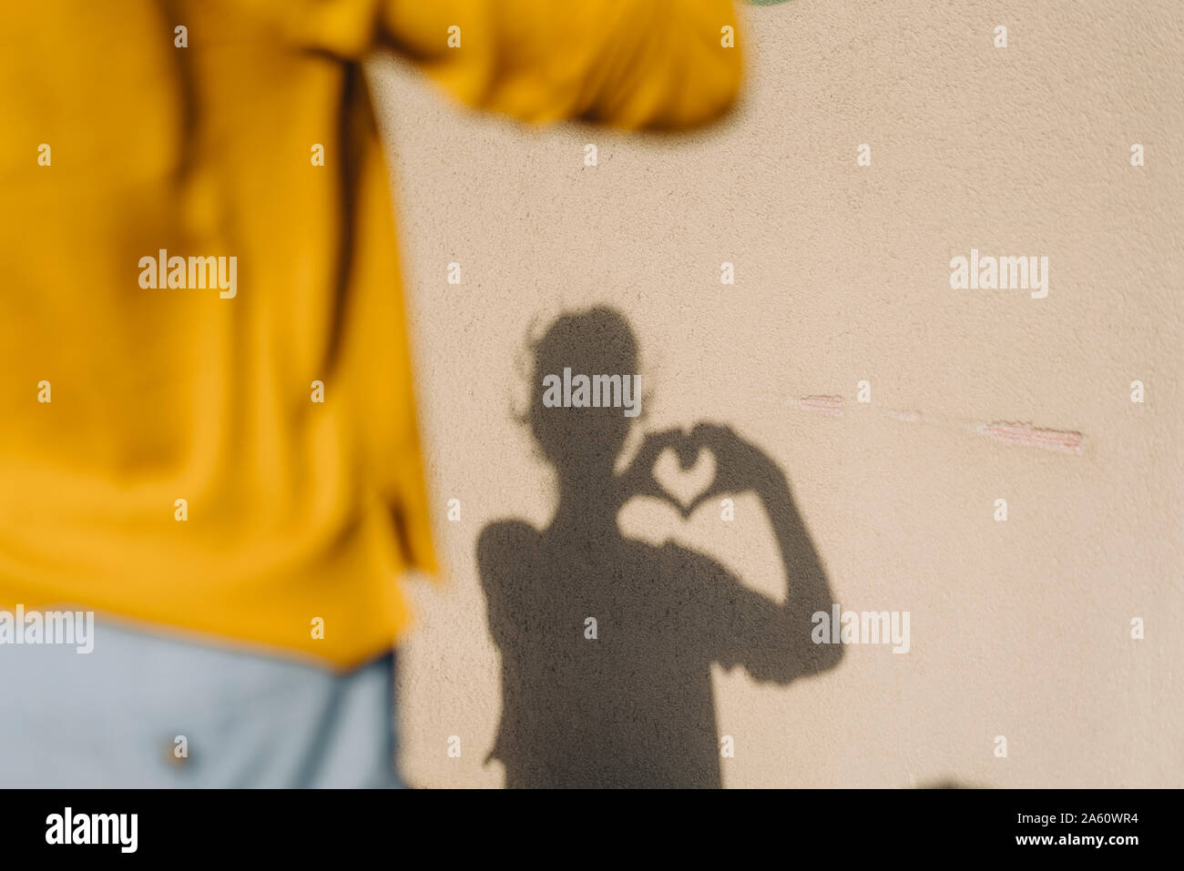 Shadow of a woman shaping a heart with her hands Stock Photo