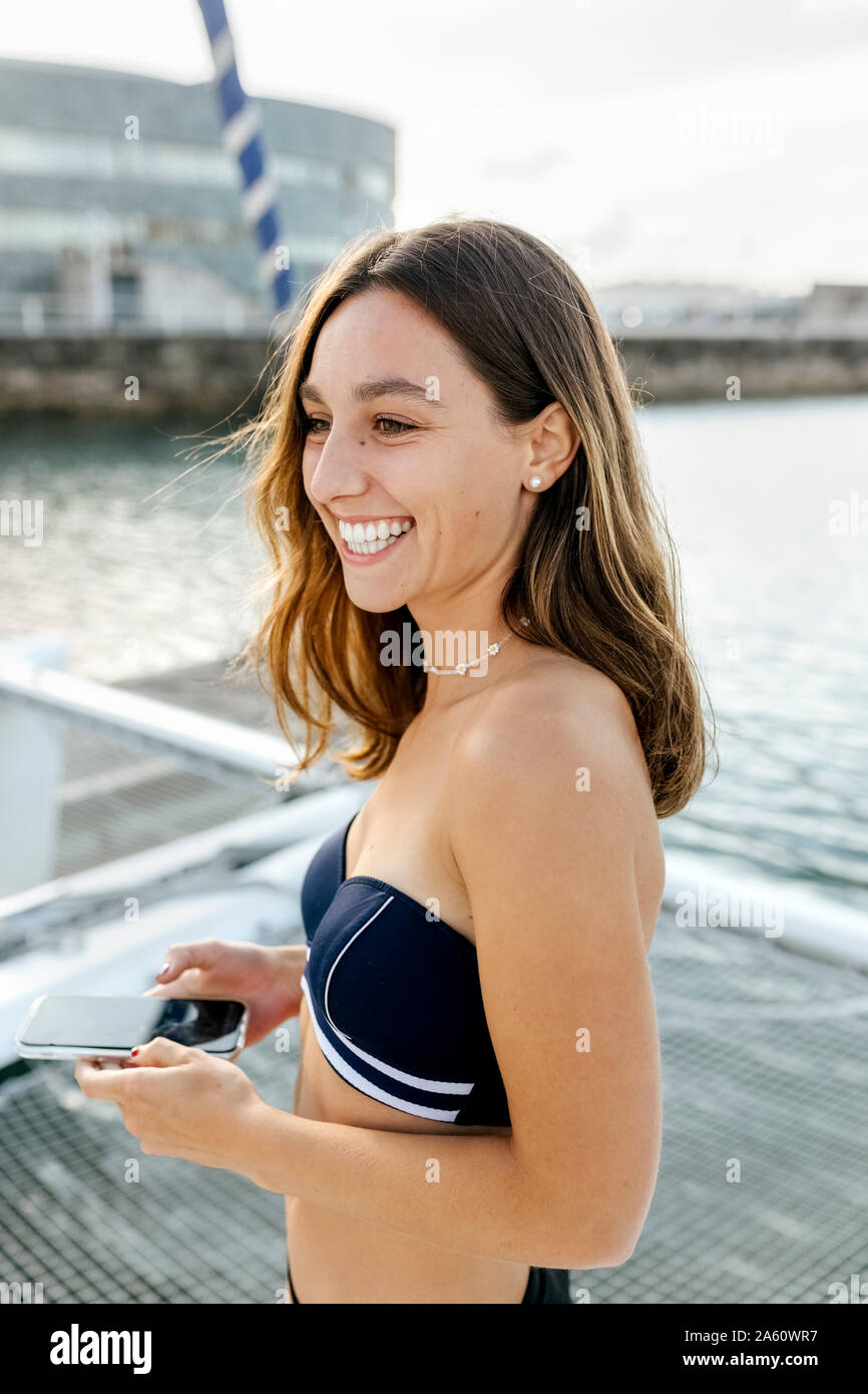 Young beautiful woman using smartphone on a sailboat Stock Photo