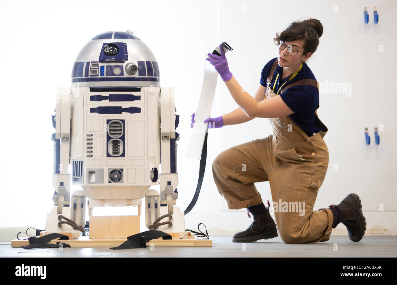 Museum technician Jessie Giovane Staniland checks the original R2-D2, used in the 1977 Star Wars film, as it arrives at V&A Dundee where it will be the centrepiece of the forthcoming Hello, Robot exhibition. Stock Photo