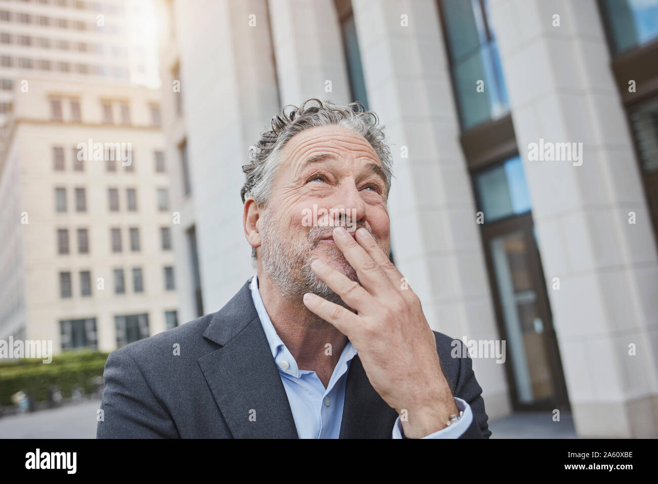 Portrait of happy businessman in the city looking up Stock Photo