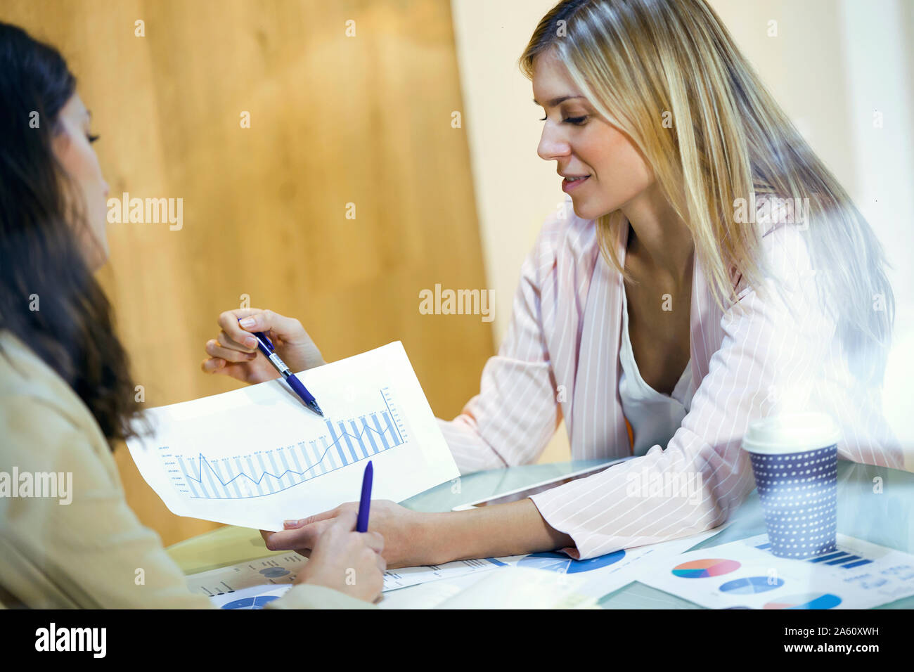Businesswoman having a meeting with colleague sharing graphs Stock Photo