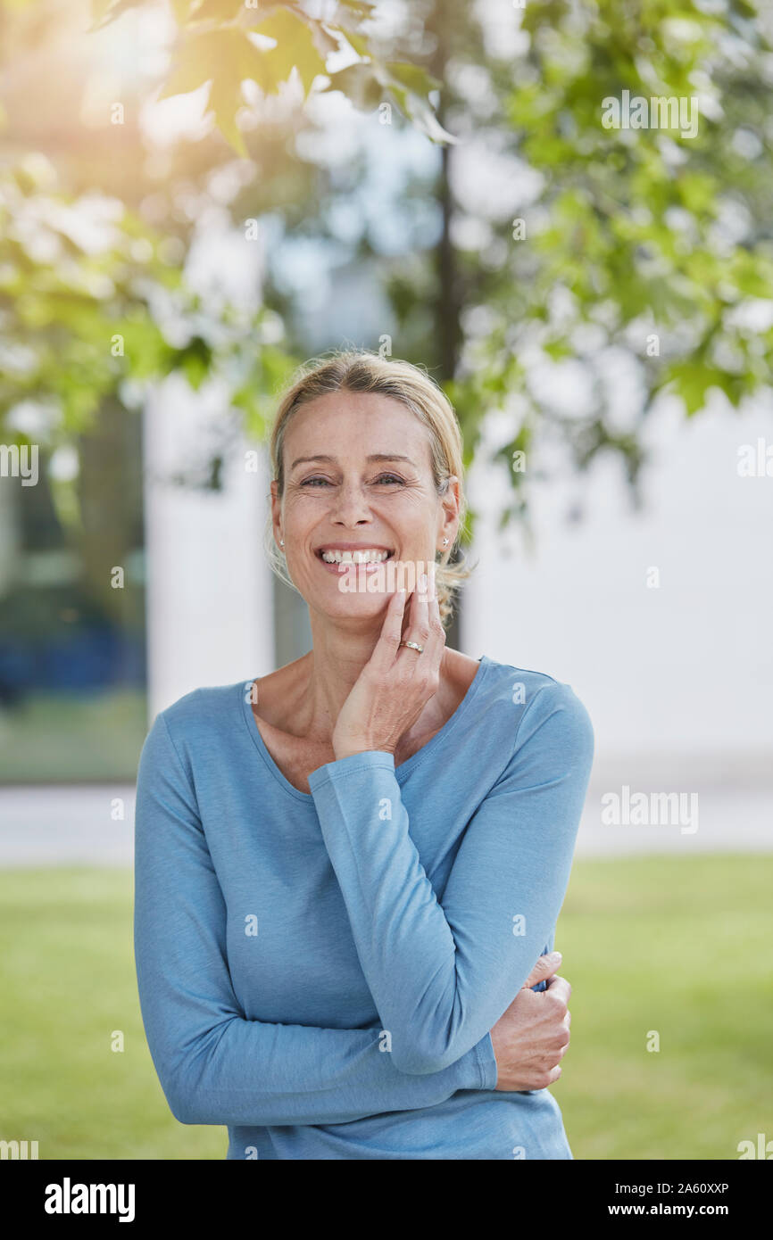 Portrait of happy blond woman in a park Stock Photo