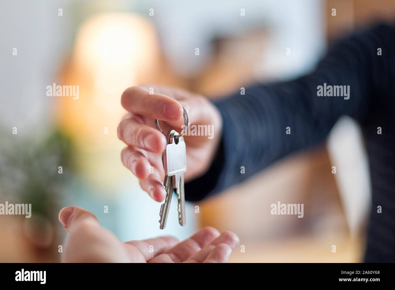Close-up of hand over of house key in new home Stock Photo