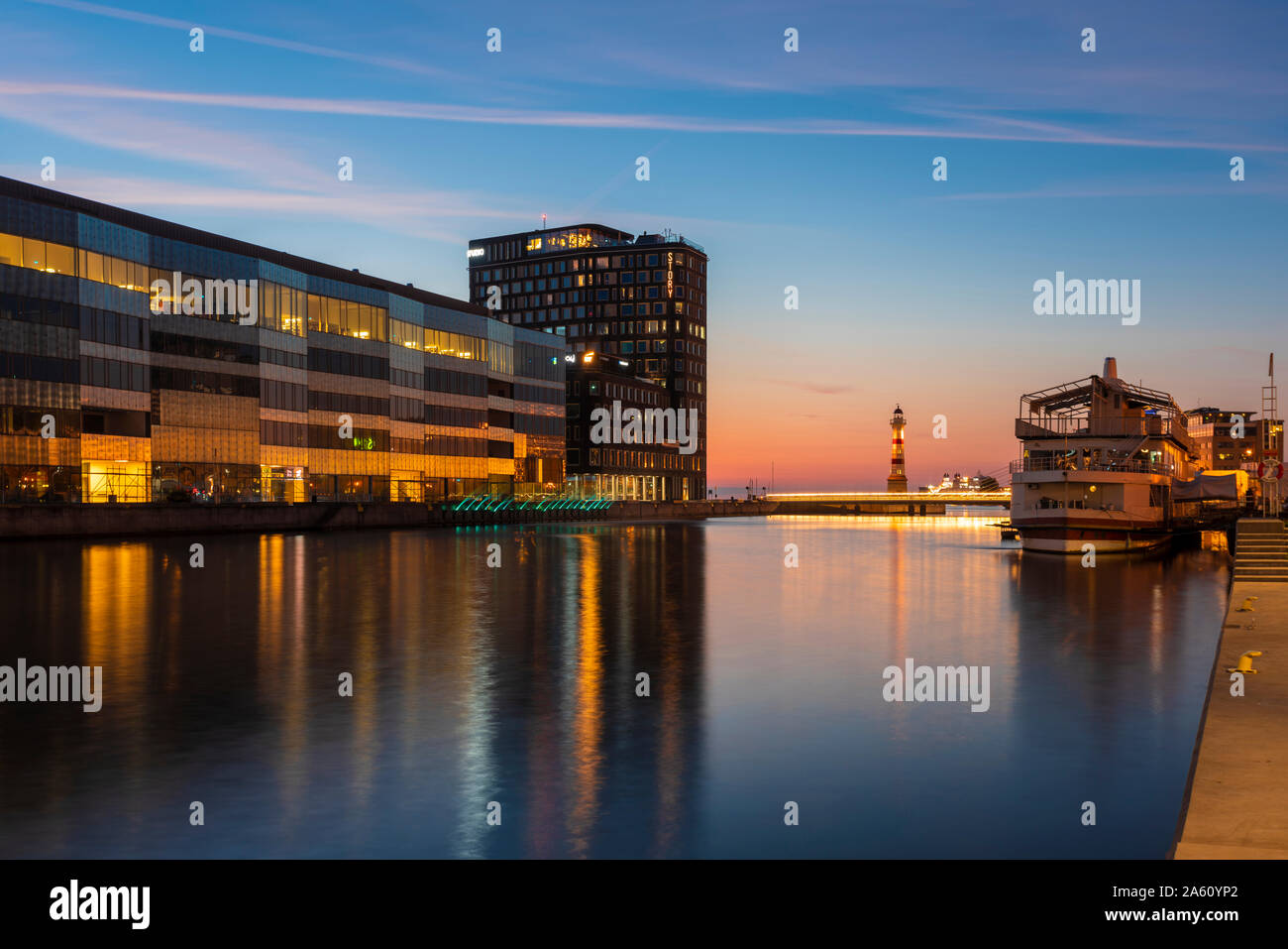 Illuminated buildings by river against sky in Malmo, Sweden Stock Photo
