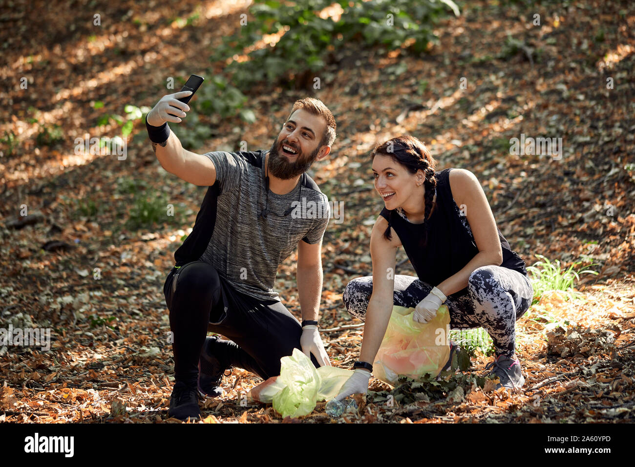 Couple taking a selfie during plogging in forest Stock Photo