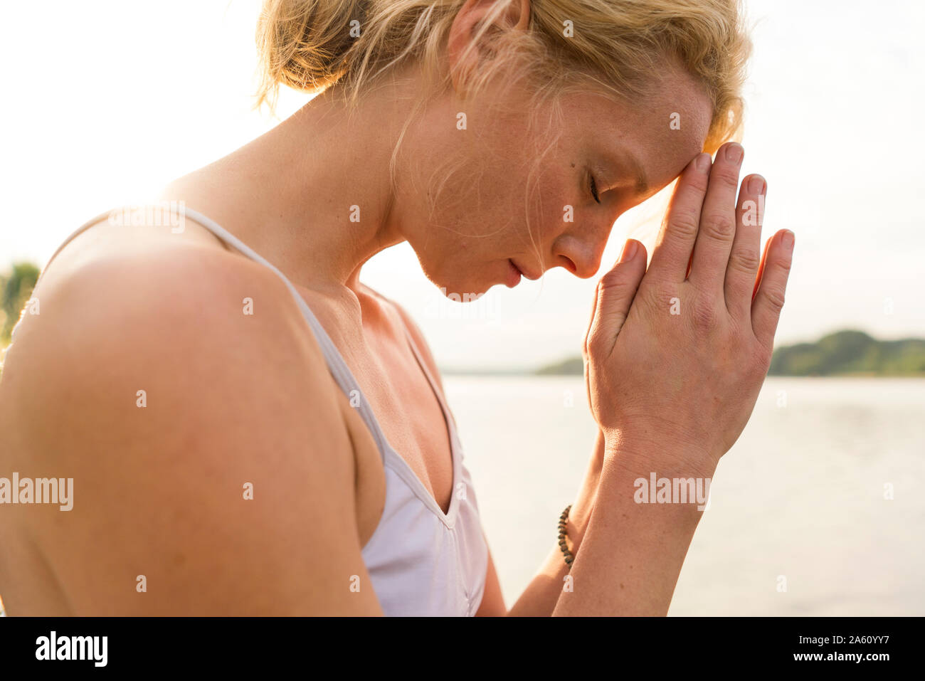 Close-up of young woman with closed eyes at a lake Stock Photo