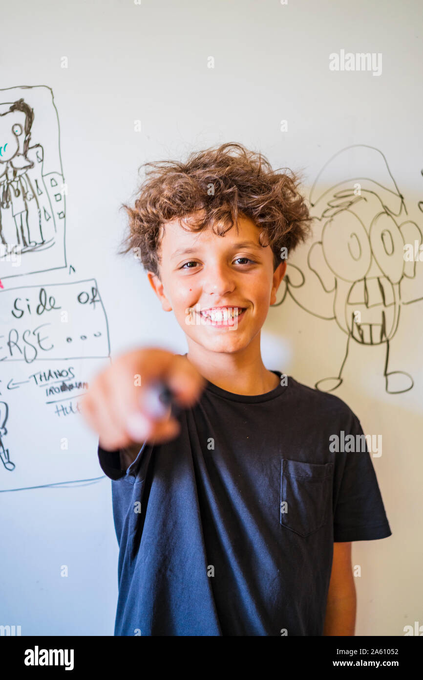Portrait of happy boy in front of drawing on a whiteboard Stock Photo