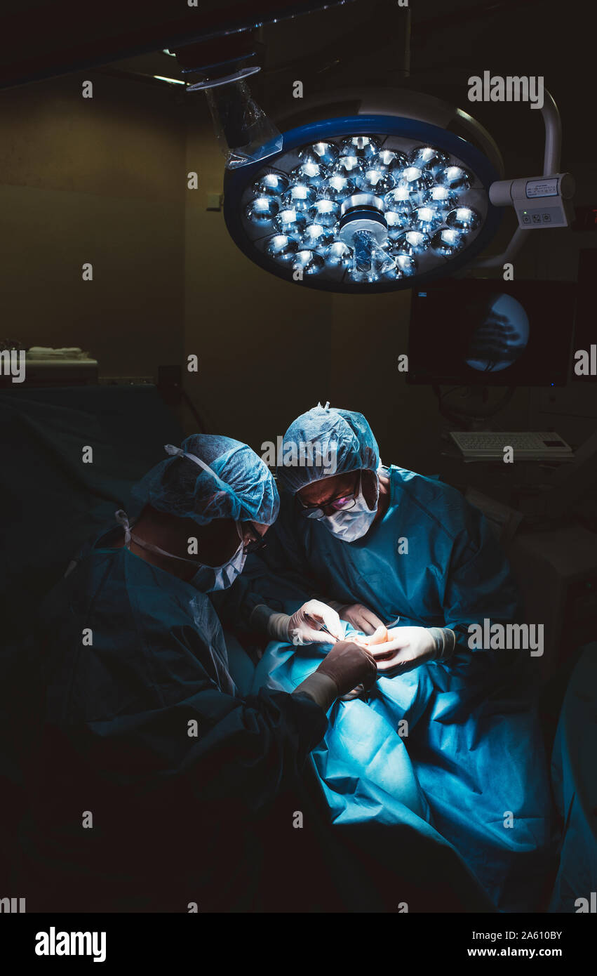 Surgeons during a foot surgery Stock Photo