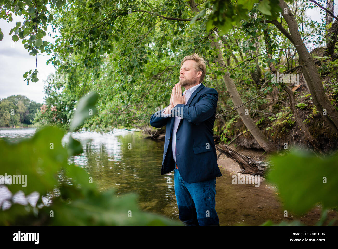 Businessman standing in a lake meditating Stock Photo