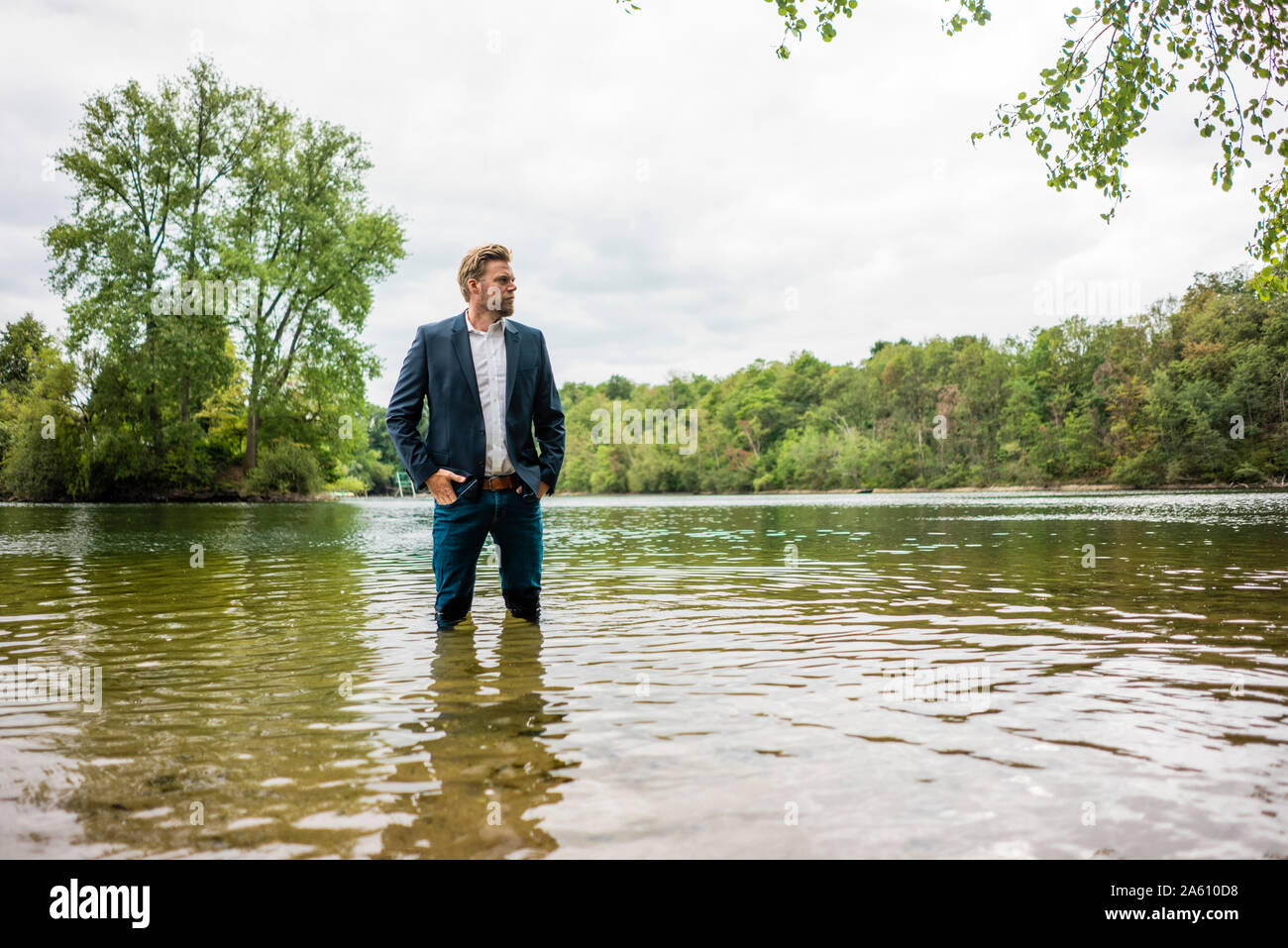Businessman standing in a lake looking out Stock Photo