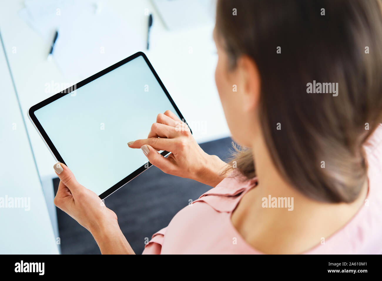 Overhead view of woman using tablet in office Stock Photo