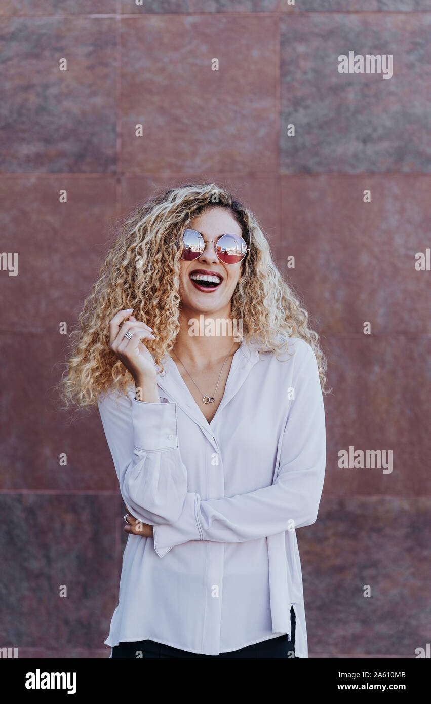 Portrait of laughing young woman wearing sunglasses Stock Photo