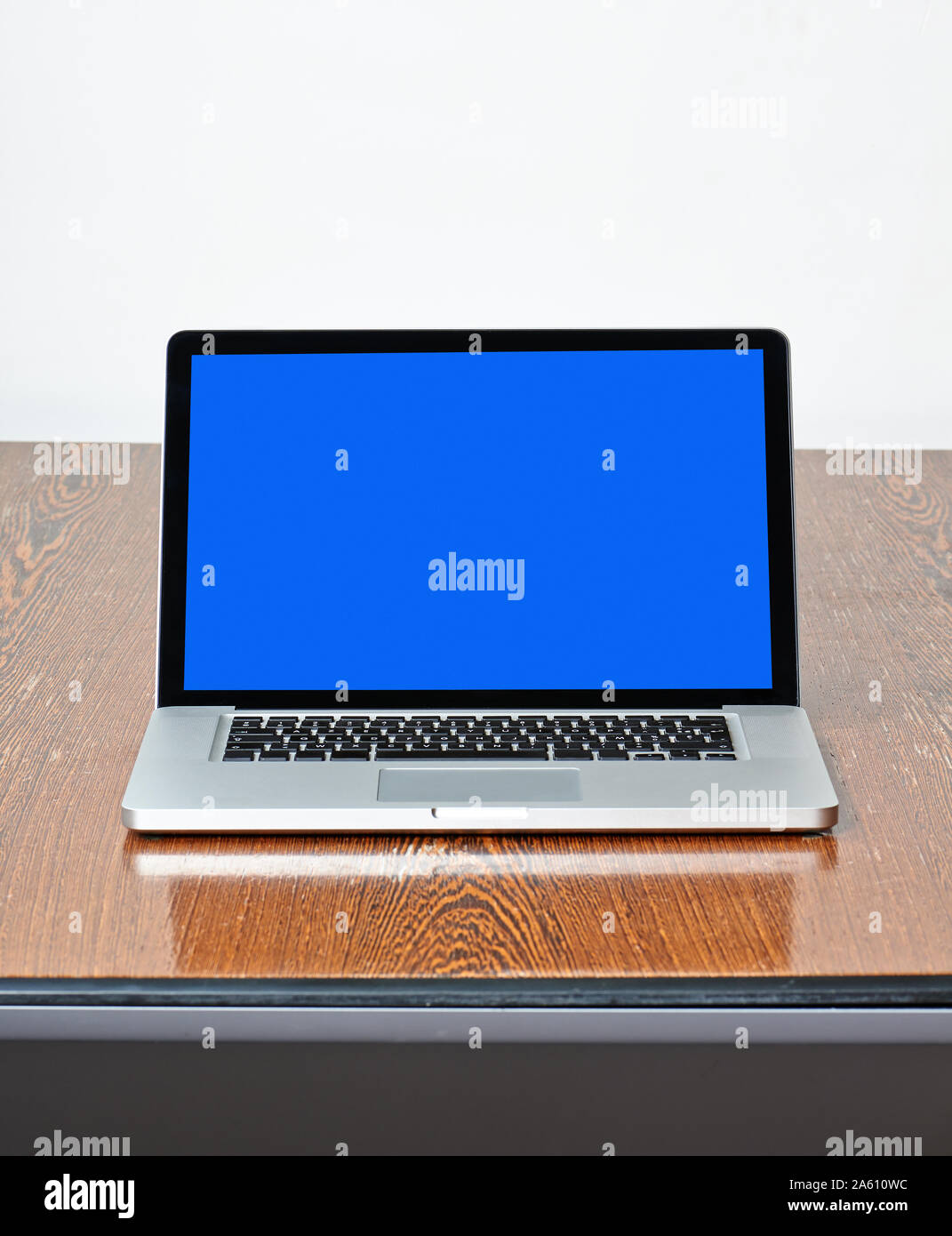 Modern laptop on textured wooden desk view from front Stock Photo