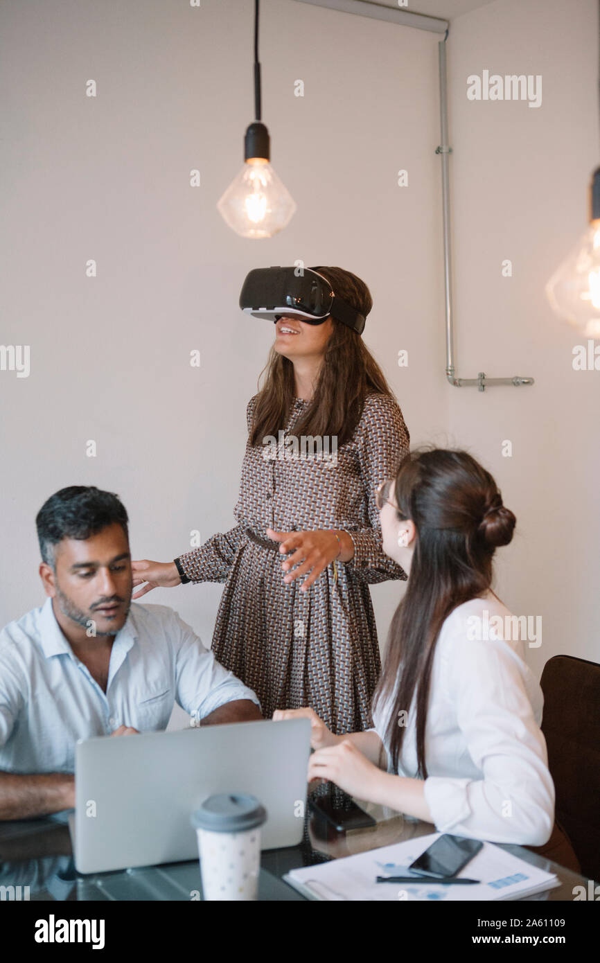 Colleagues working in office testing VR simulator Stock Photo