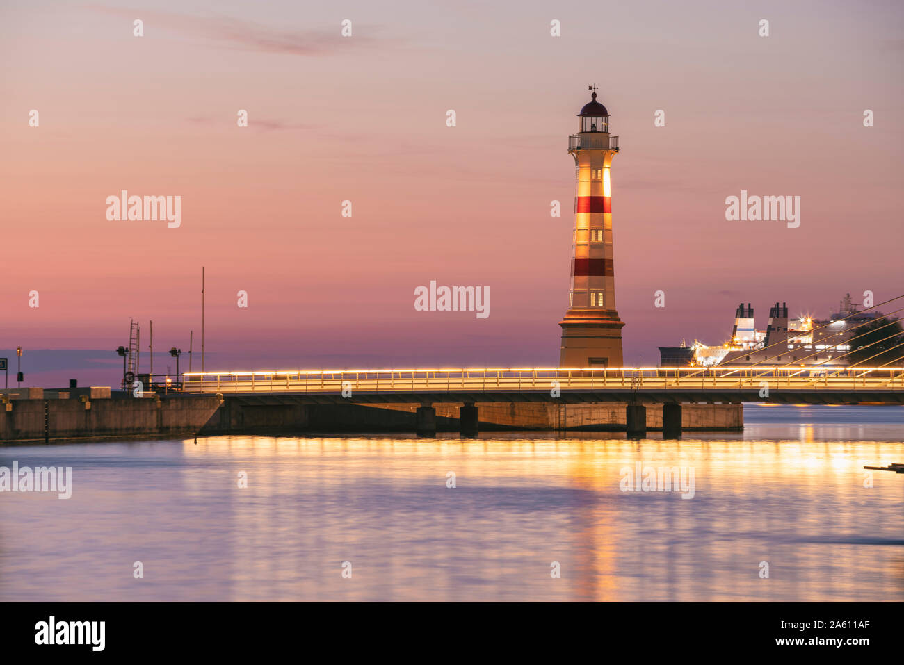 Illuminated bridge over river with lighthouse in background against sky at Malmo, Sweden Stock Photo