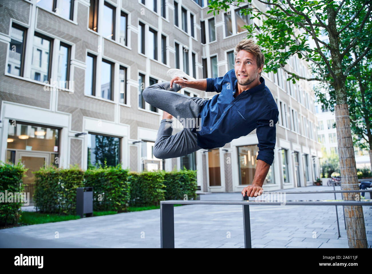 Young man jumping over railing in the city Stock Photo