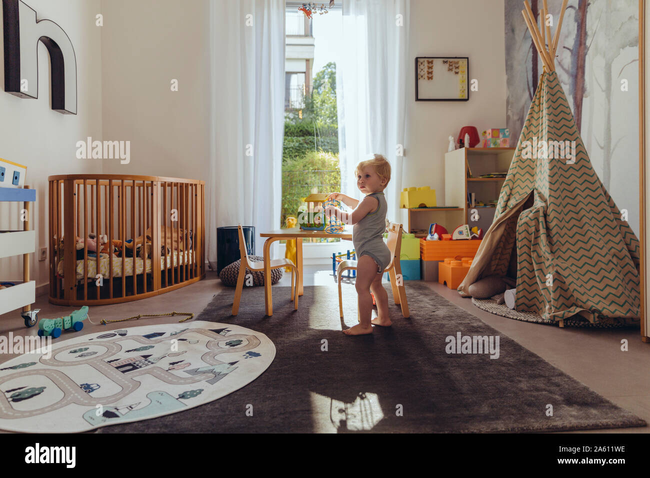 Baby boy playing in his nursery Stock Photo