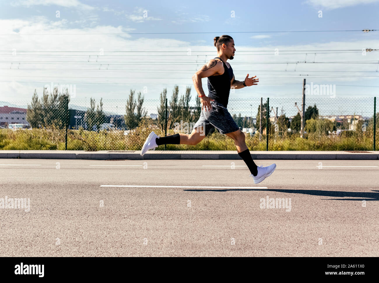 Sporty young man running on a road Stock Photo