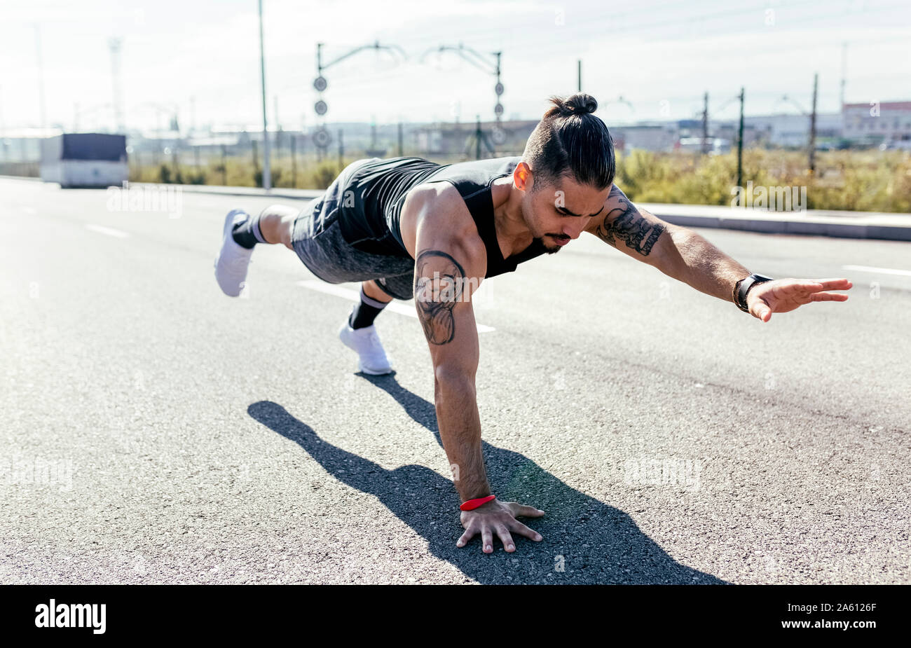 Young man doing balance exercise on a road Stock Photo