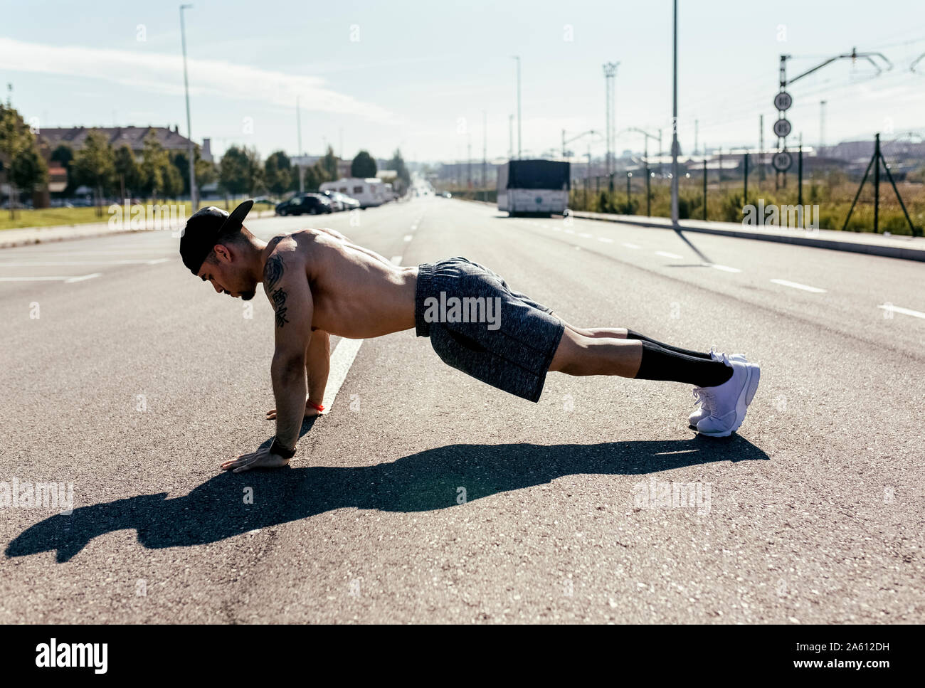 Young man doing push ups on a road Stock Photo