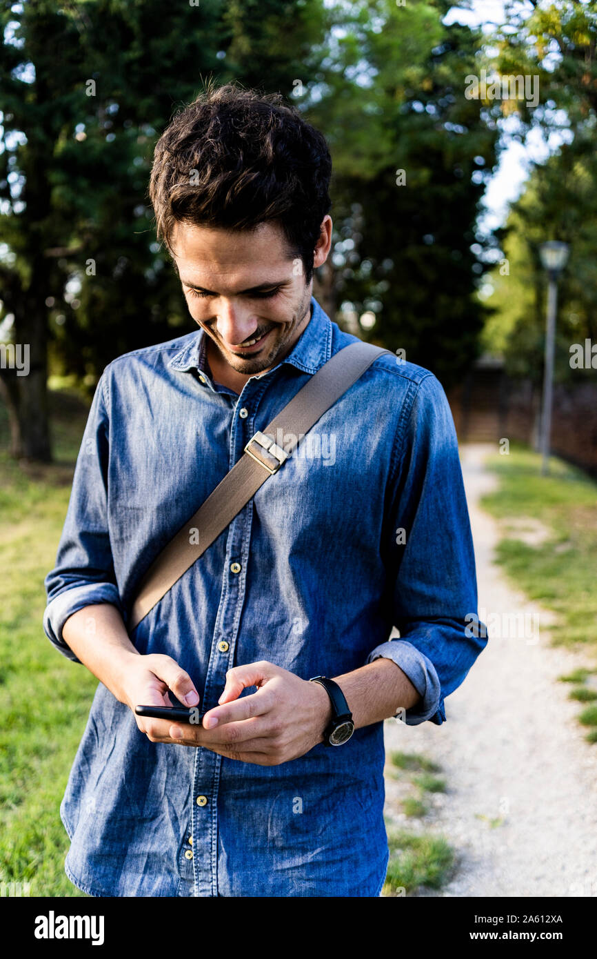Man smiling holding smartphone hi-res stock photography and images - Alamy