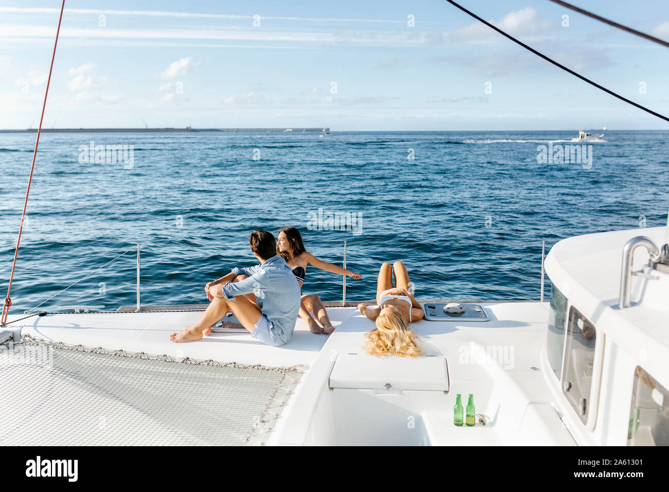 Three young friends enjoying a summer day on a sailboat Stock Photo