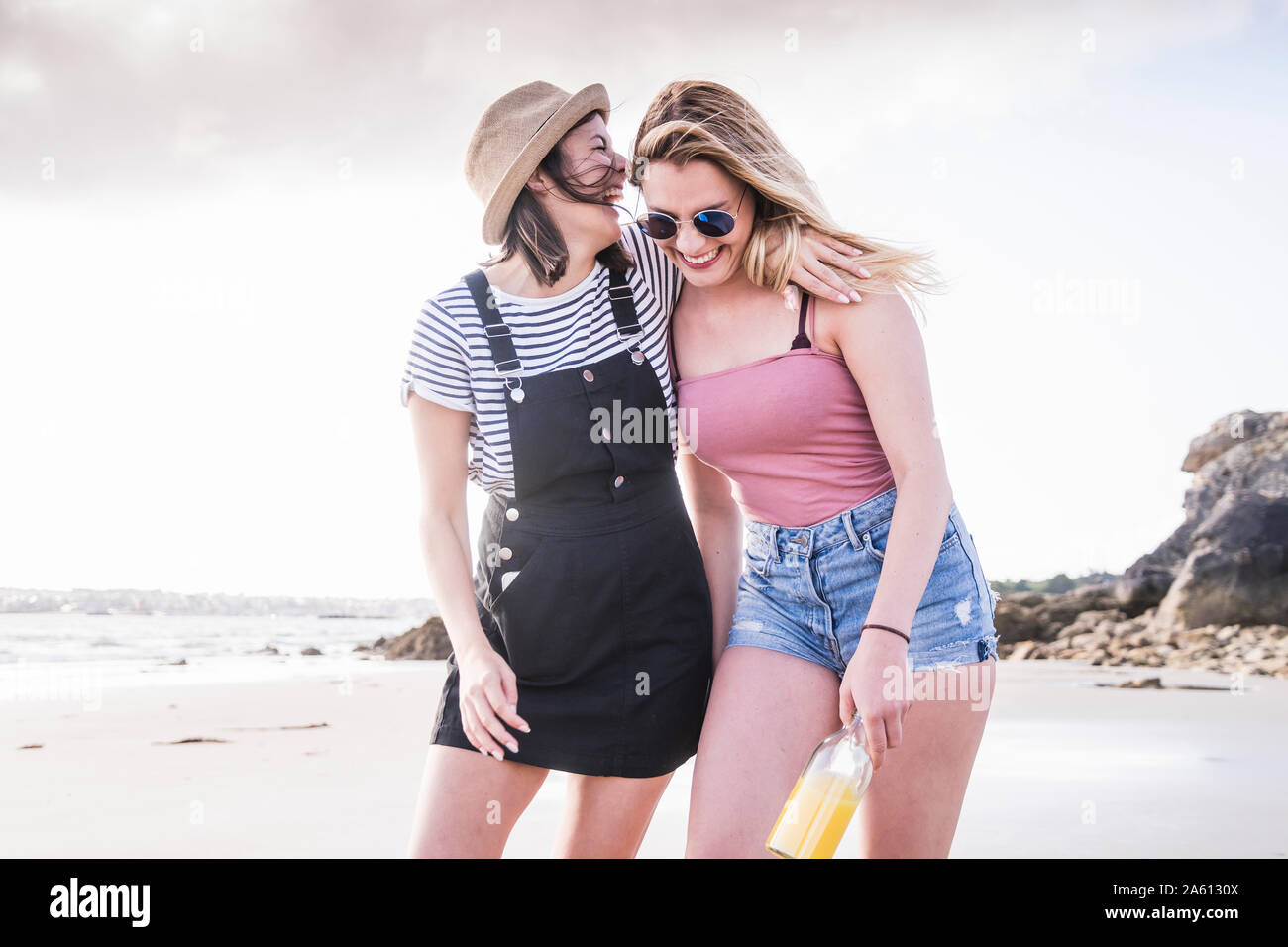 Two girlfriends having fun, walking on the beach Stock Photo