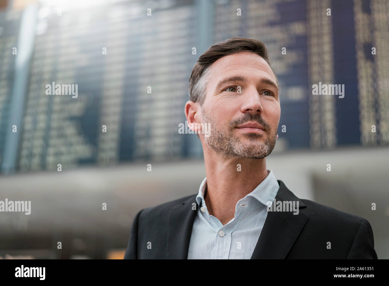 Portrait of businessman at arrival departure board at the airport Stock Photo