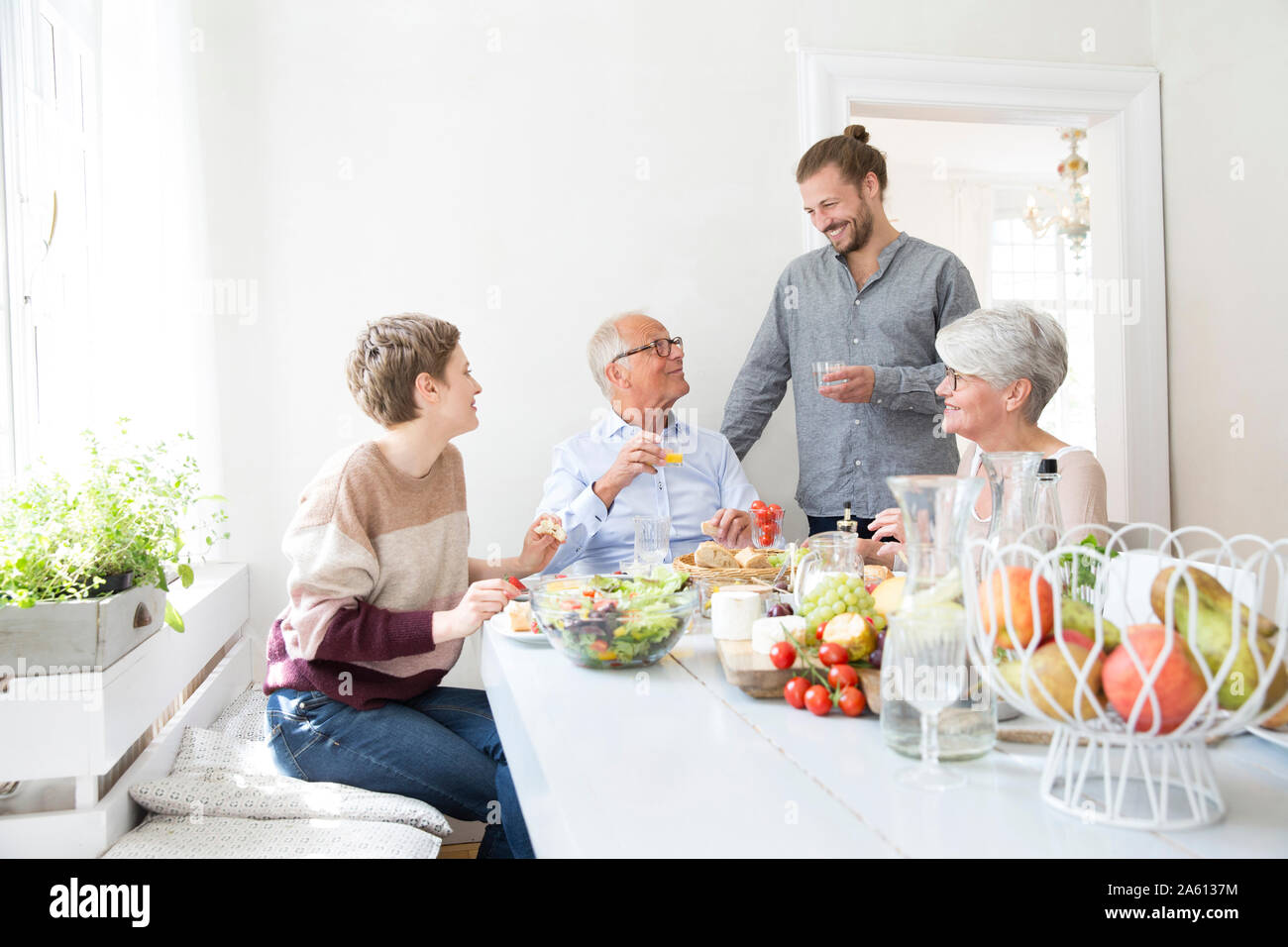 Happy senior couple with adult children having lunch at home Stock Photo