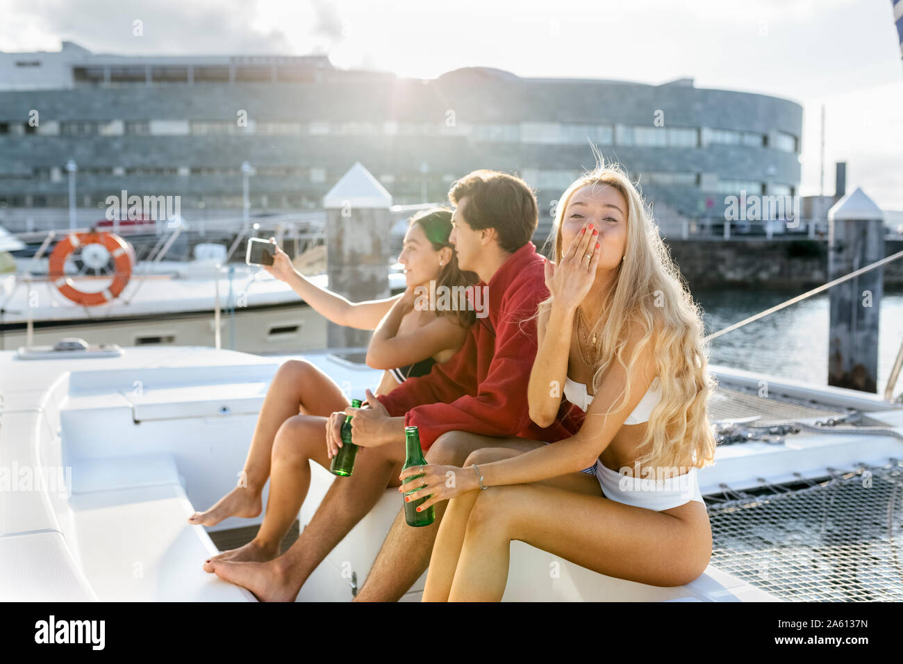 Three young friends enjoying a summer day on a sailboat, taking a selfie Stock Photo