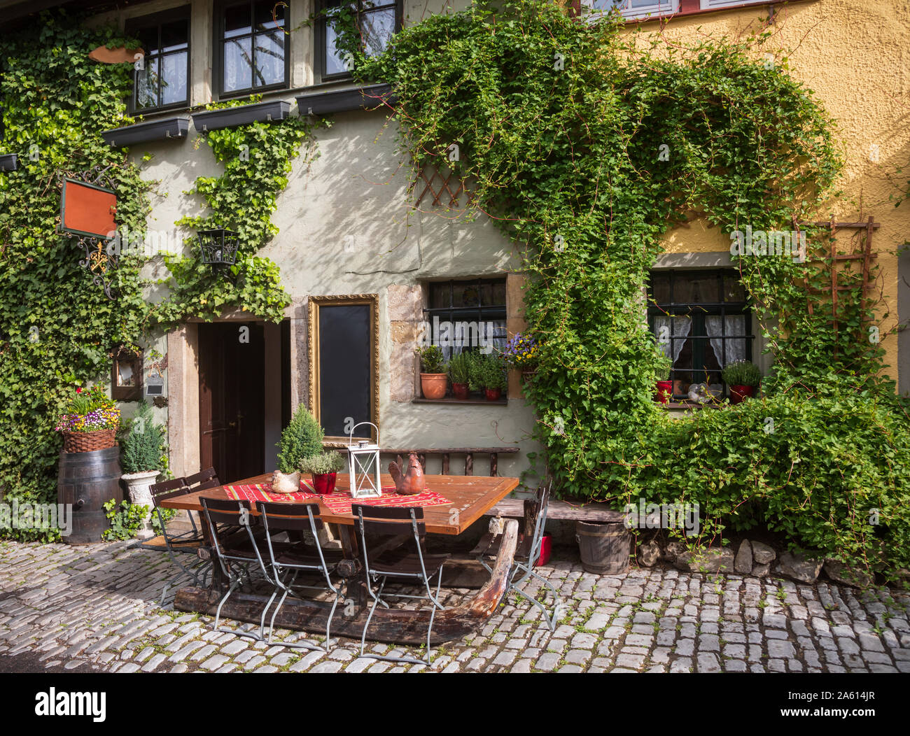 Romantic street cafe decorated with climbing plants on Romantic Road touristic route in Bavaria, Germany Stock Photo