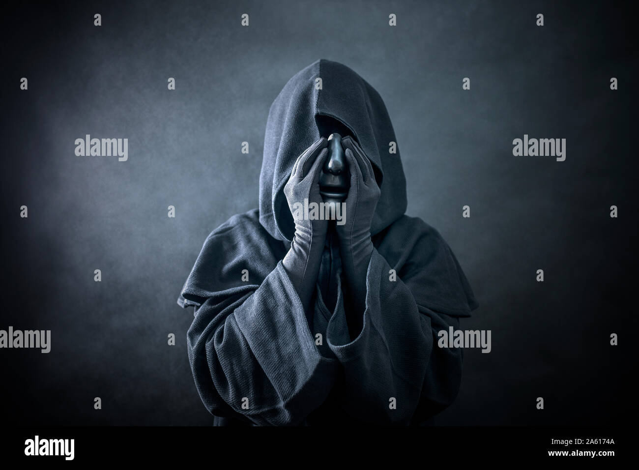 Ghostly figure hooded cloak. Scary figure with part of mannequin head in hands Stock Photo - Alamy