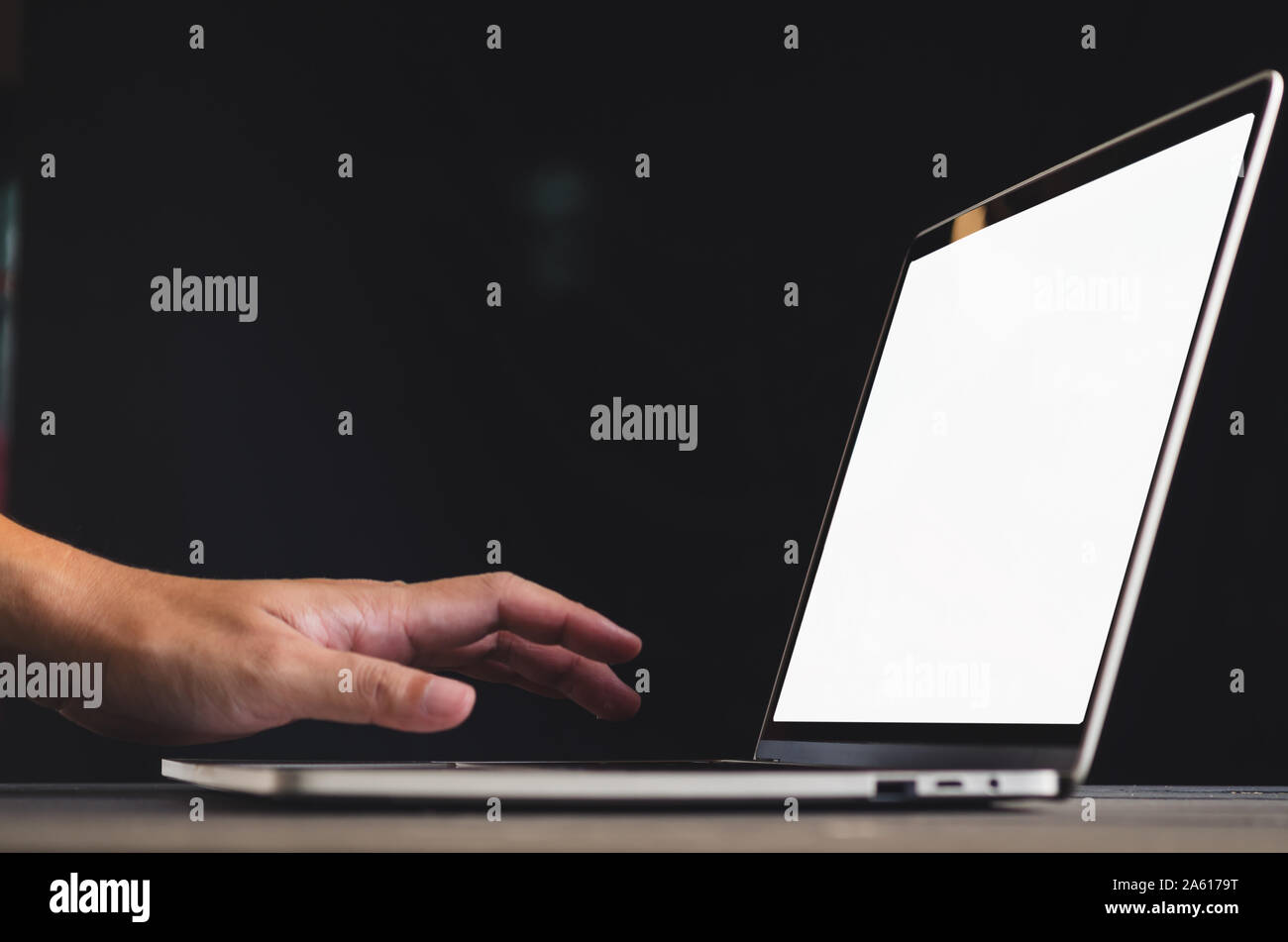 human hand in front of laptop on the table with blank, mockup image of ...