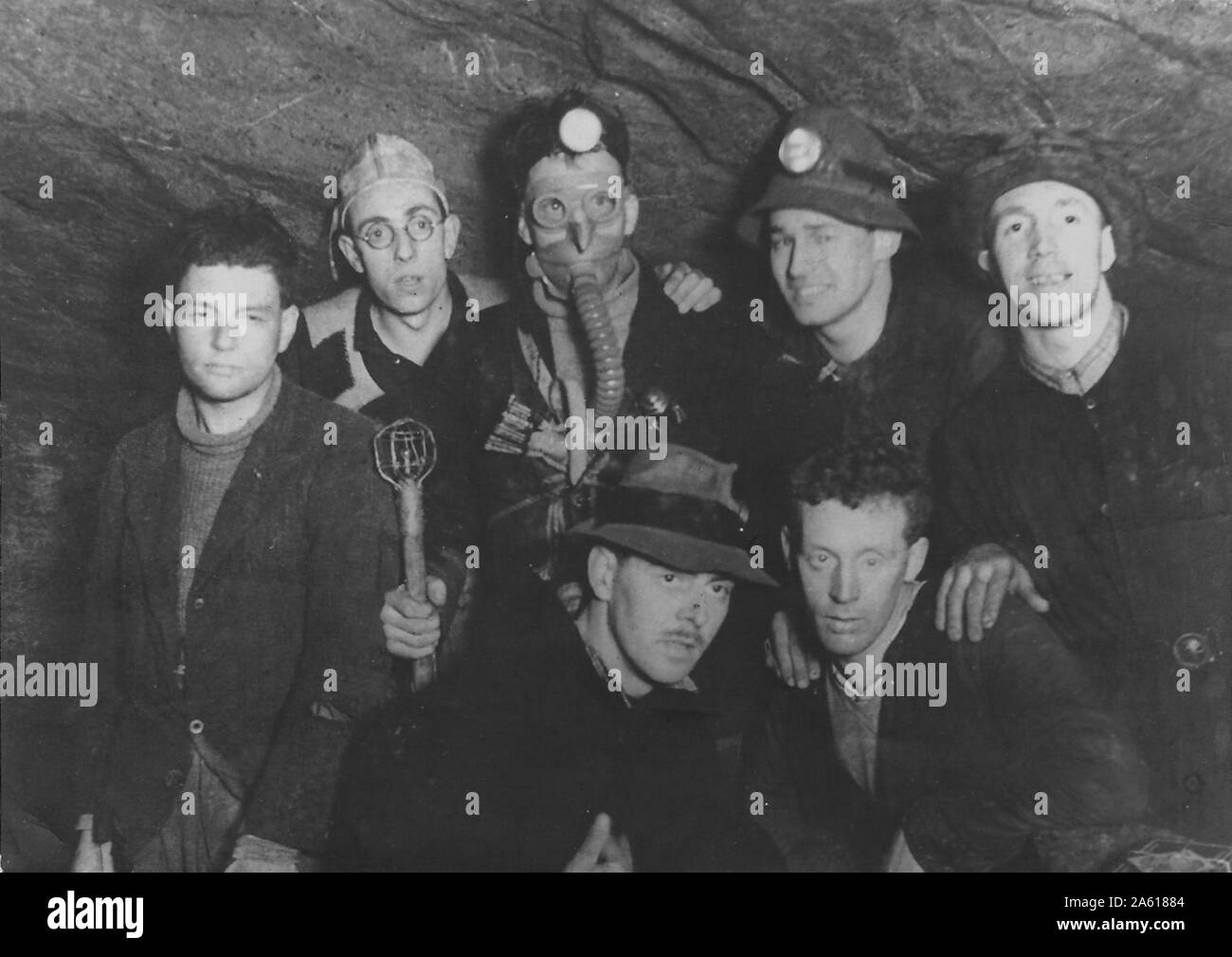 A group of men pose underground in a cave, some wearing respirators, miner's lamps and other gear during a Northern Cavern and Fell Club rock climbing and spelunking event in Yorkshire, United Kingdom, 1934. () Stock Photo