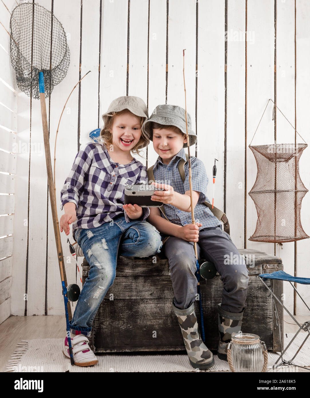 two little smiling children making selfie sitting on old big chest Stock Photo