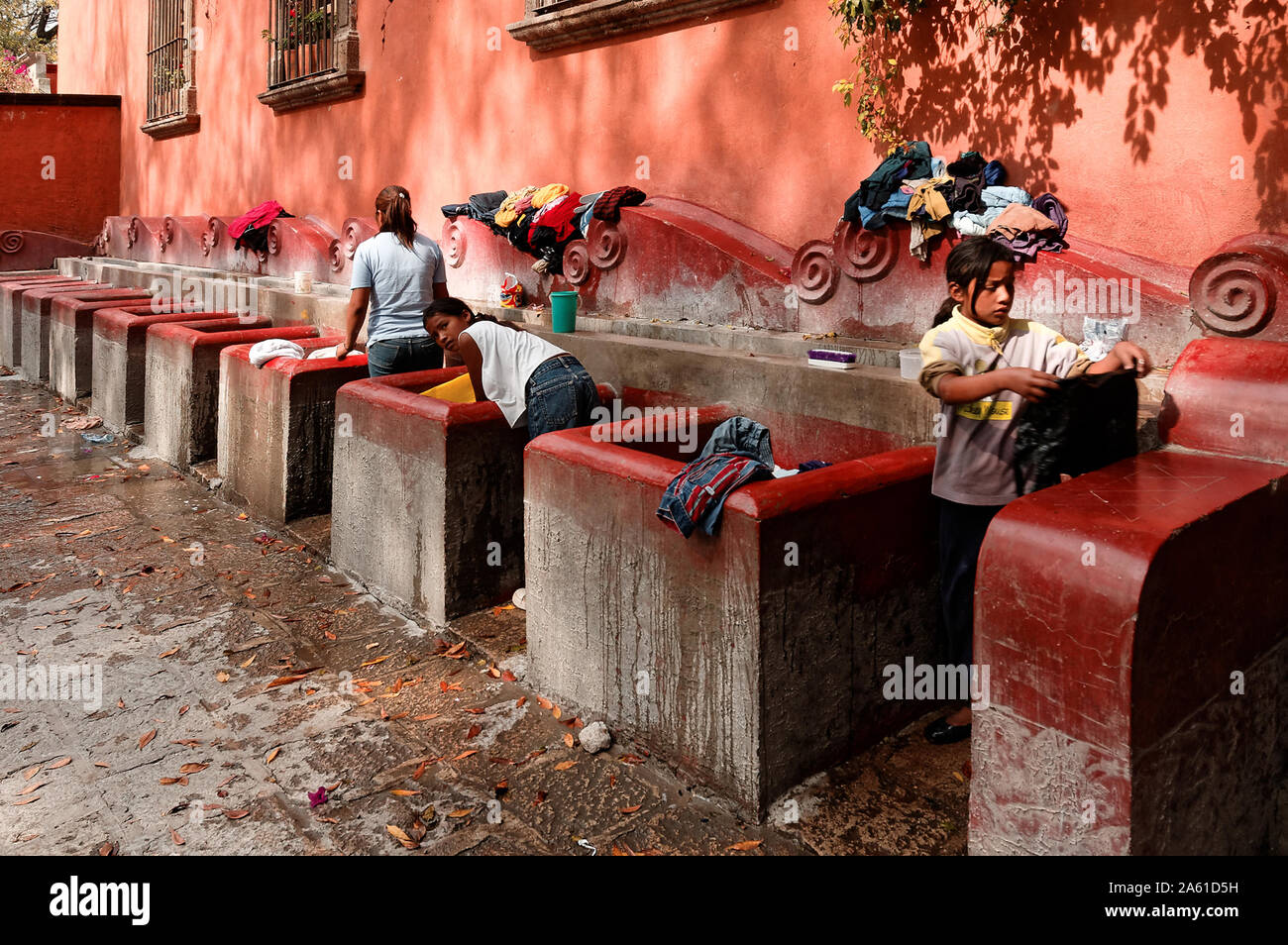 San Miguel de Allende, Guanajuato, Mexico - December 5, 2004: Girls hand wash clothes at the public laundry. Stock Photo